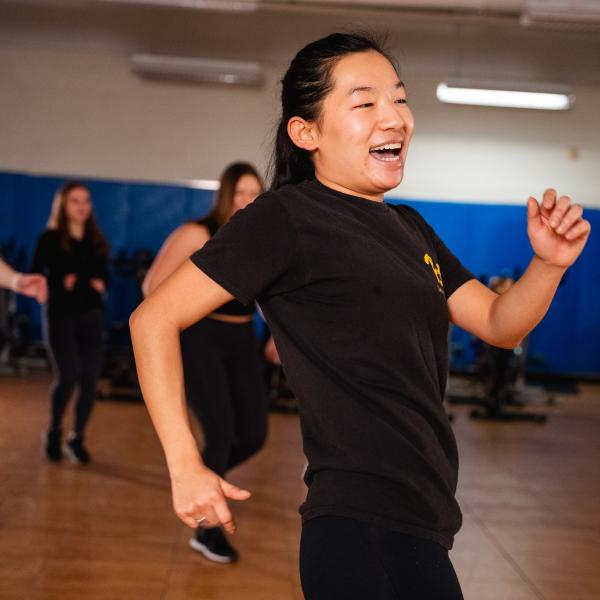 A woman dancing in a black t-shirt.