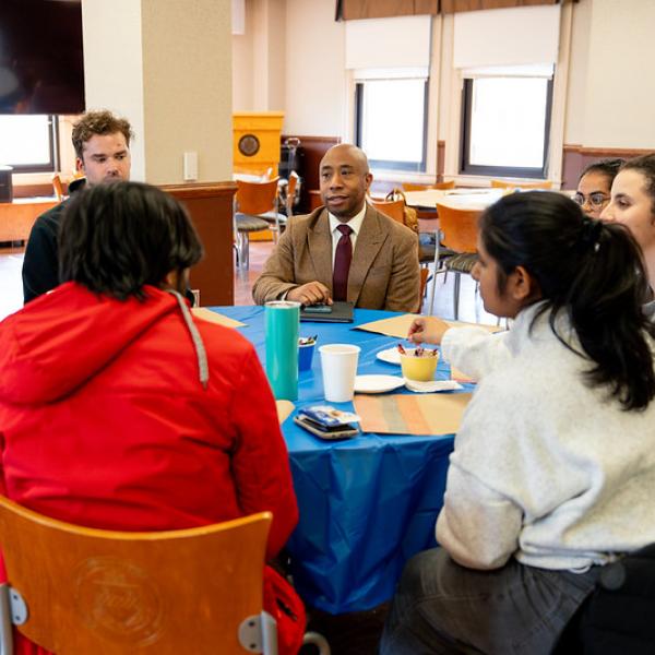 Dean Nabors sitting at a table with five students.