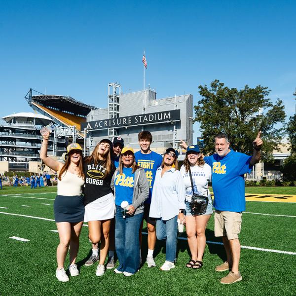 A family of 7 standing in front of Acrisure Stadium.