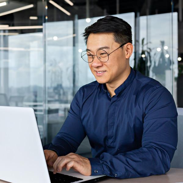 Man smiling and typing on laptop