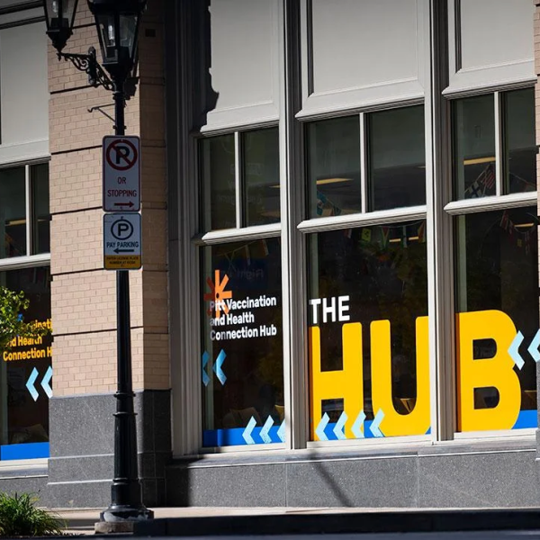 Building with a large street-facing glass window with the word HUB in bright yellow letters.