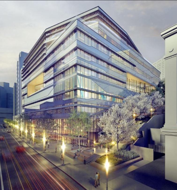 A futuristic glass building surrounded by light and street-lining trees.