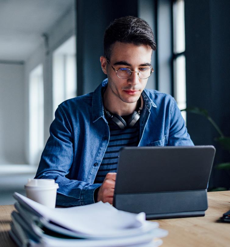 Man at desk looking at iPad.