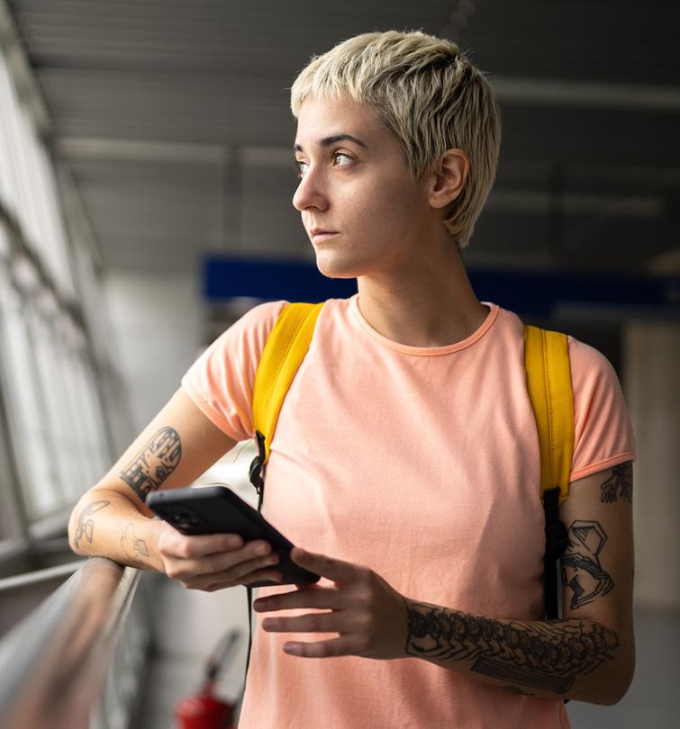 Woman standing holding cell phone.