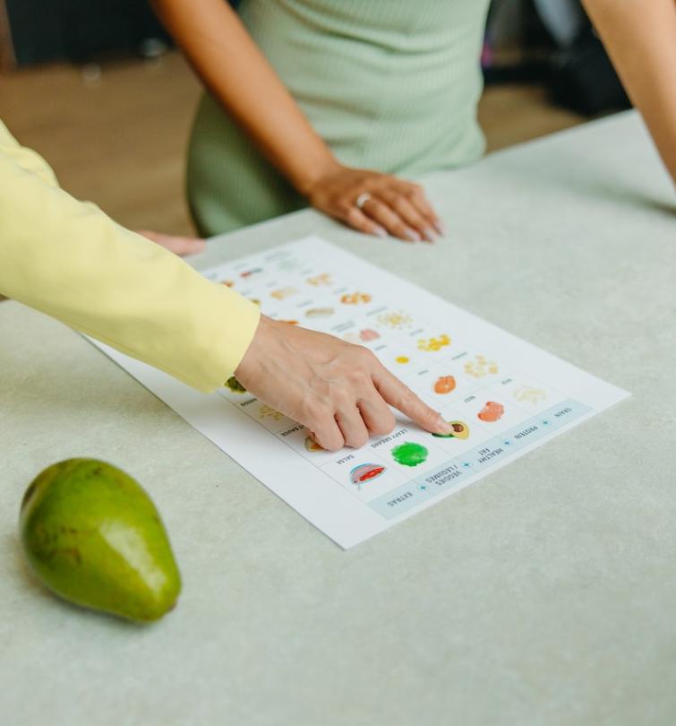 Two people point to details on a nutrition-related diagram.