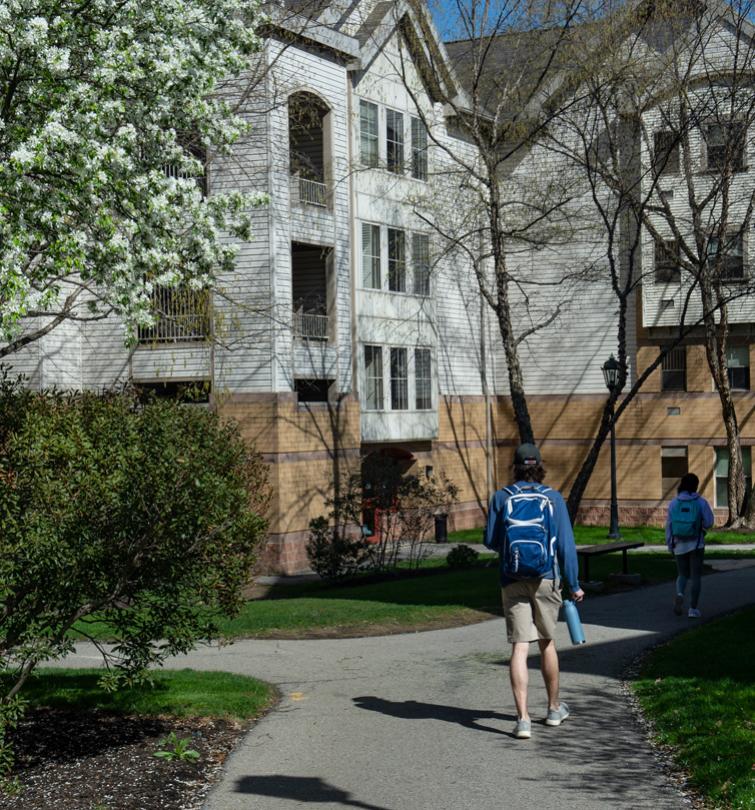 Student standing in front of residence hall.