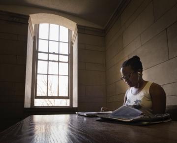 A person works at a desk in a dark room.