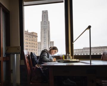 A person works at a desk in a dark office.