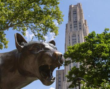 A dark panther statue in front of the Cathedral of Learning.