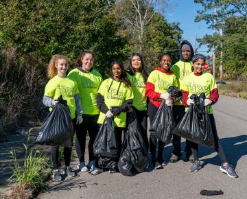 A group of neon-clad volunteers pose outdoors.