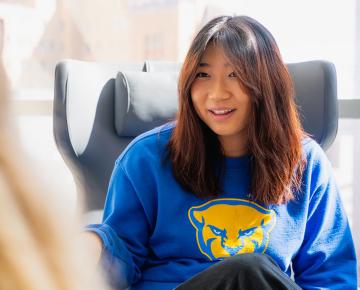 A female student with red hair and a blue sweatshirt.