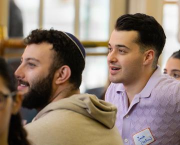 Two male students listening to a speaker.