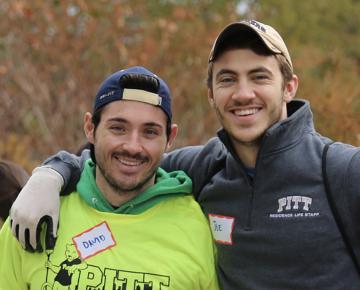 Three volunteers in neon garb outdoors pose for a photo.