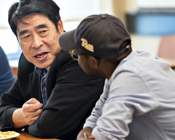 Two people chatting at table.