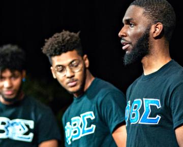 Students wearing matching tee shirts with Greek letters.