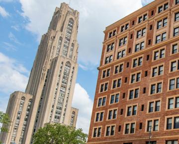 The Cathedral of Learning and WIlliam Pitt Union, two ornate, stately buildings with a green lawn between them.