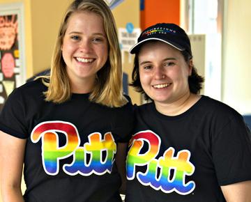 Two students smiling with rainbow Pitt shirts on.