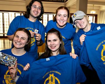 Students holding up Pitt shirts.