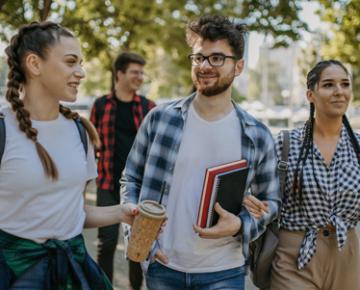 Stock photo of young people outside holding notebooks