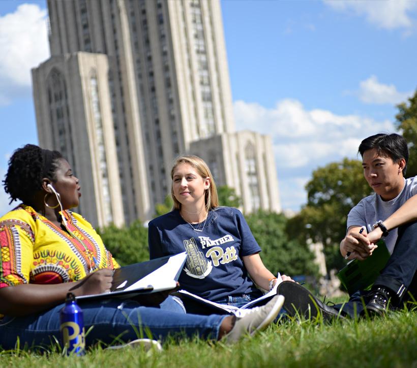 Three students sitting in Cathedral lawn