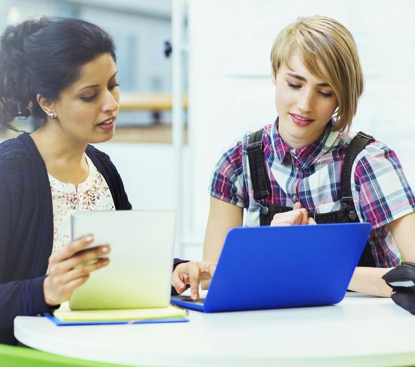 Two people at table with laptop.