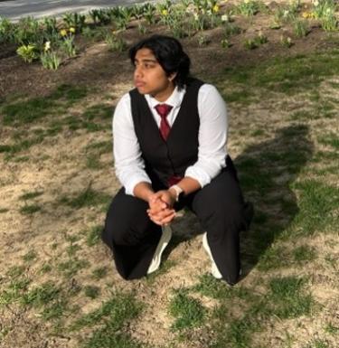 Person in suit kneeling outside
