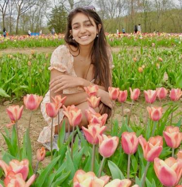 Young woman in flower field smiling