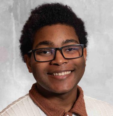 Young man in sweater in front of white backdrop