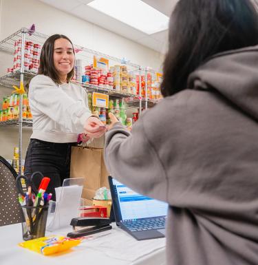 Woman accepting a can from over a food service counter.