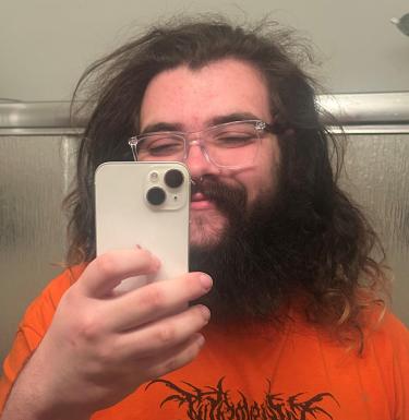 Young person in orange shirt taking a selfie