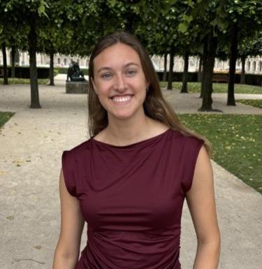 Young woman in red shirt smiling outdoors