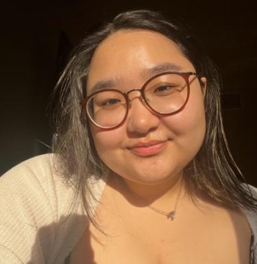 Young woman in glasses smiling in sunlight