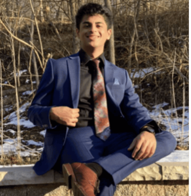 Man in blue suit sitting outside