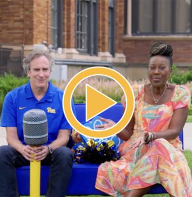 A man and a woman sitting outside on a blue couch.