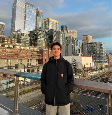 Young man smiling in front of city skyline