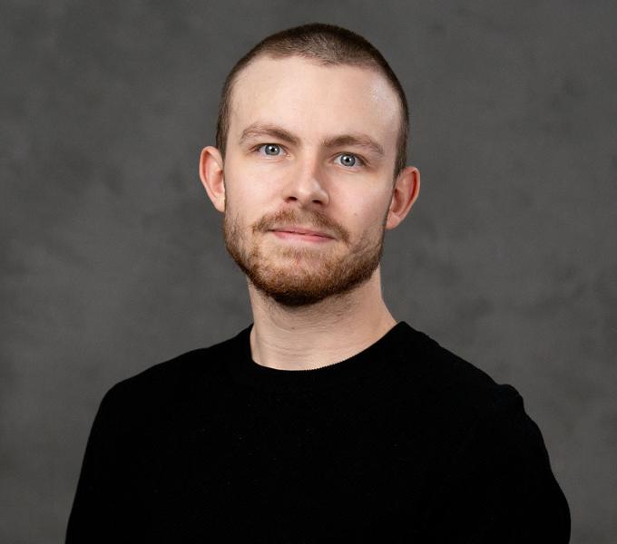 Man with short dark hair in a black tshirt.