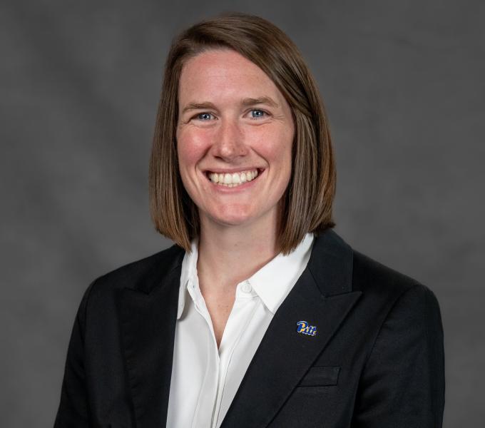 Headshot of a smiling woman with cropped shoulder-length light brown hair.