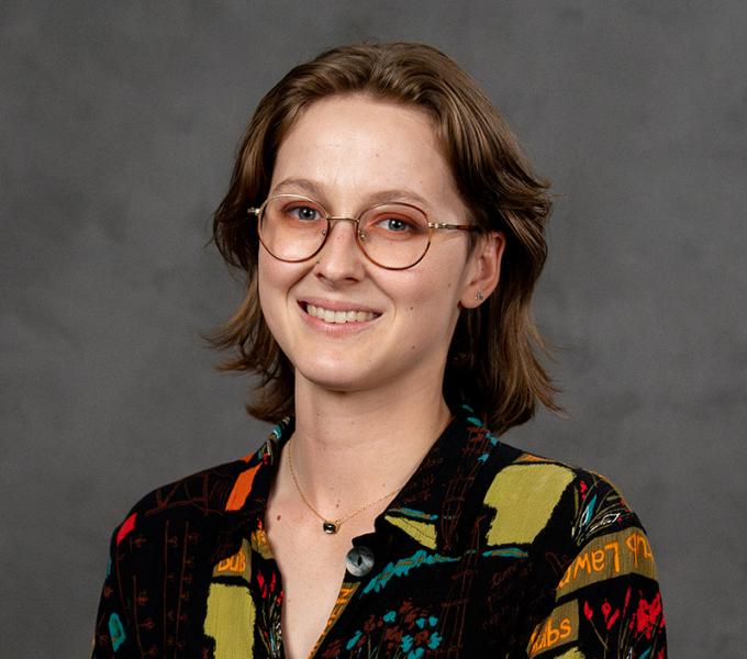 Photo of a woman with short brown hair and glasses smiling.