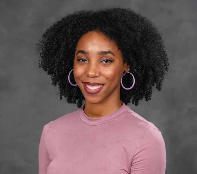 Headshot of a smiling woman wearing a pink shirt.