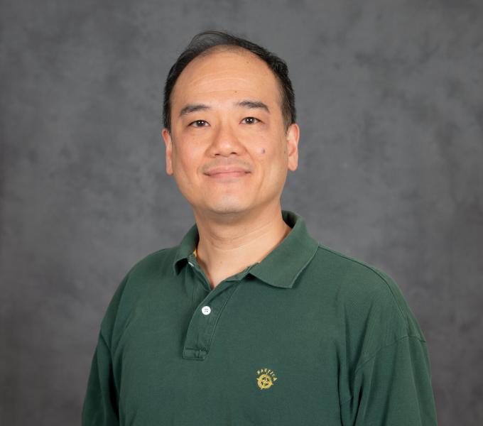 Headshot of smiling man in sage green polo.