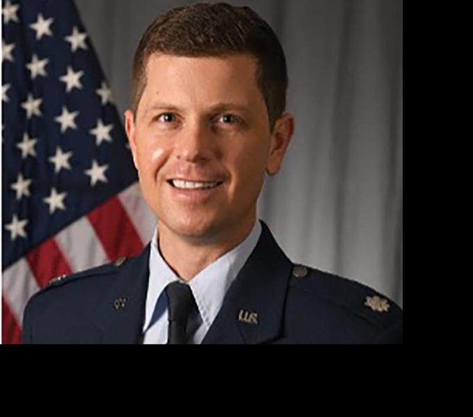 Lt Col Robert Chance smiling in front of an American flag.