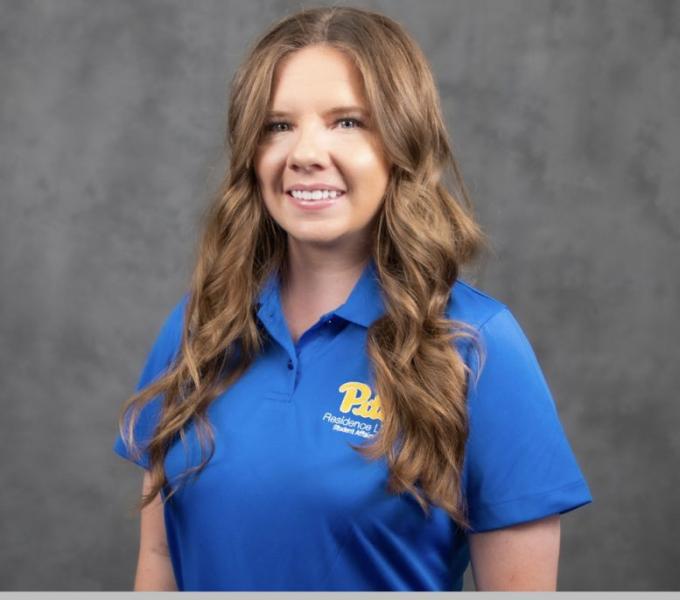 Headshot of a smiling woman with dark blonde hair in a blue Pitt-branded polo shirt.